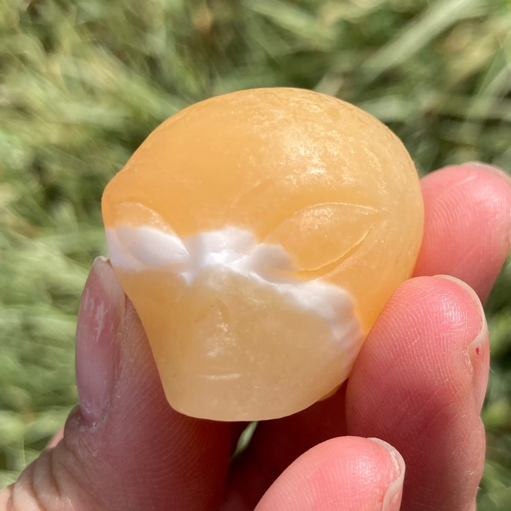 Yellow calcite alien head carving